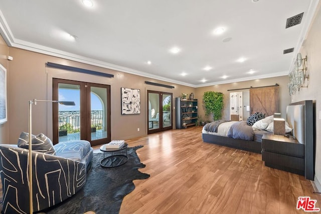 bedroom with wood-type flooring, a barn door, french doors, and access to outside