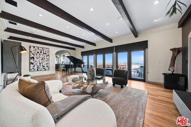 living room with beamed ceiling and light wood-type flooring