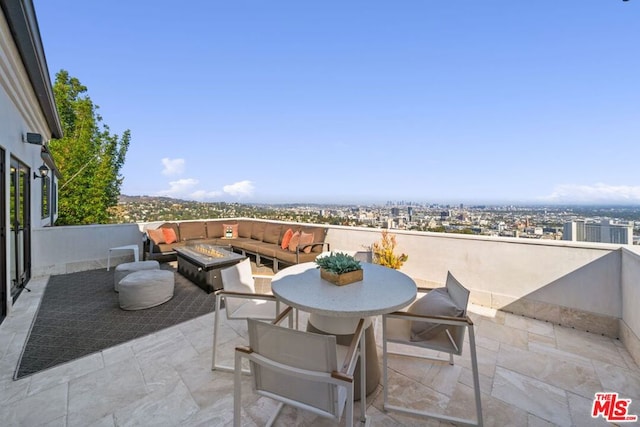 view of patio with an outdoor living space with a fire pit