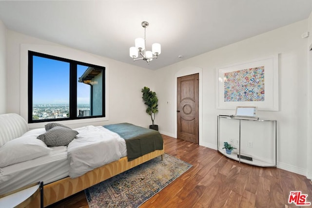 bedroom with a notable chandelier and hardwood / wood-style floors