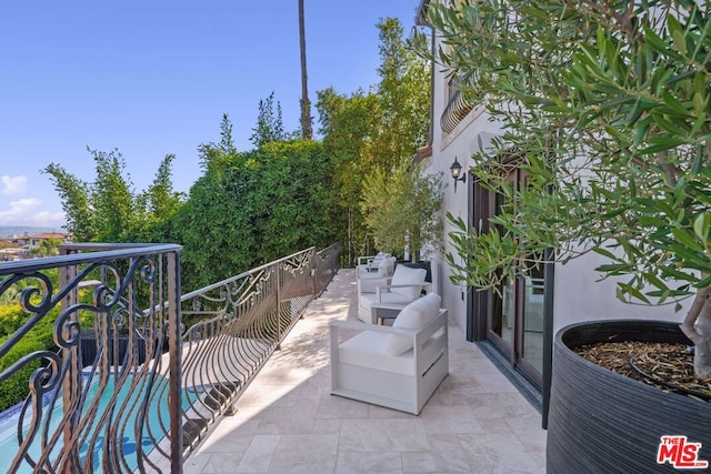 balcony with an outdoor hangout area and a patio