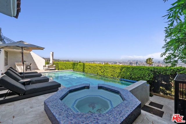 view of swimming pool featuring a patio and an in ground hot tub