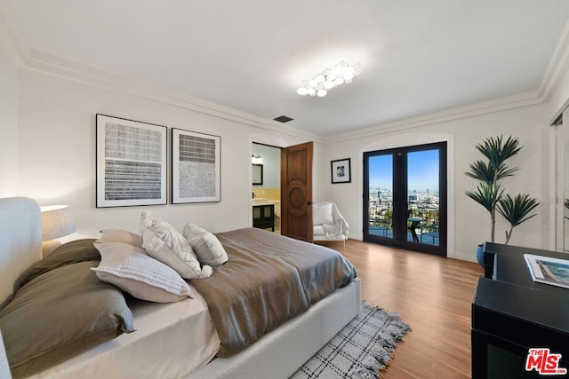 bedroom featuring french doors, light hardwood / wood-style floors, access to exterior, ornamental molding, and ensuite bathroom