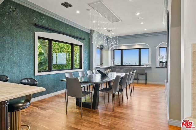 dining room featuring plenty of natural light, crown molding, and light hardwood / wood-style flooring