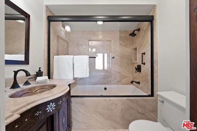 full bathroom with toilet, enclosed tub / shower combo, and vanity