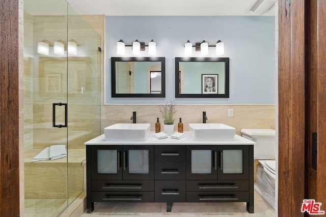 bathroom featuring vanity, tile walls, and a shower with door