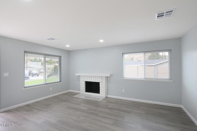 unfurnished living room featuring a fireplace and light hardwood / wood-style flooring