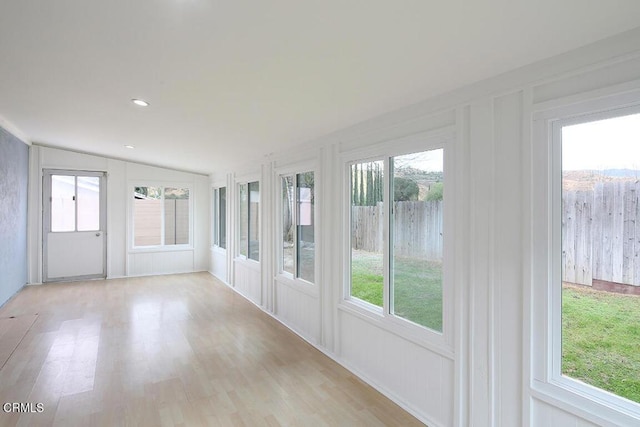 unfurnished sunroom featuring vaulted ceiling