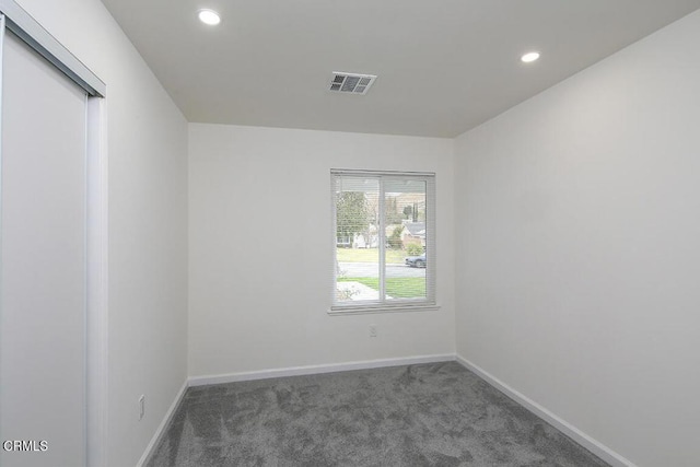 unfurnished room featuring dark carpet