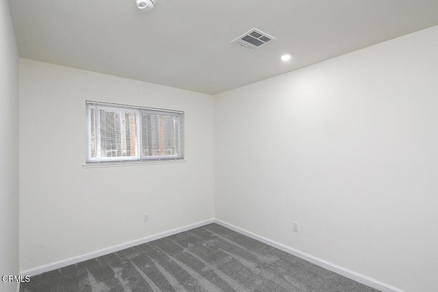 empty room featuring dark colored carpet