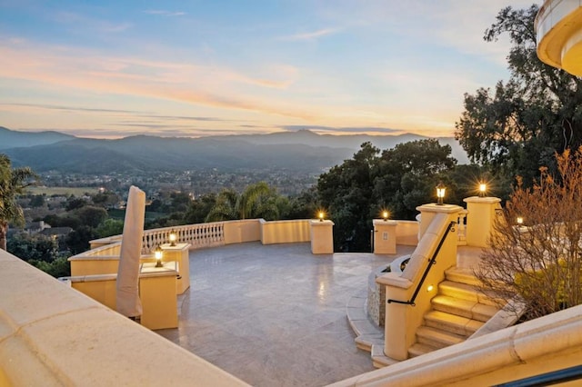 patio terrace at dusk featuring a mountain view