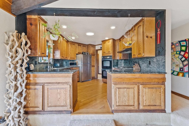 kitchen featuring tasteful backsplash, appliances with stainless steel finishes, beam ceiling, and kitchen peninsula