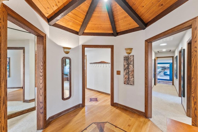 hallway featuring wood ceiling, lofted ceiling with beams, and light wood-type flooring