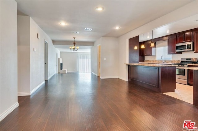 kitchen with appliances with stainless steel finishes, decorative light fixtures, dark brown cabinetry, an inviting chandelier, and dark hardwood / wood-style floors