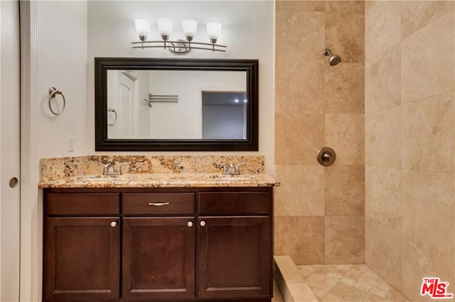 bathroom with vanity and a tile shower