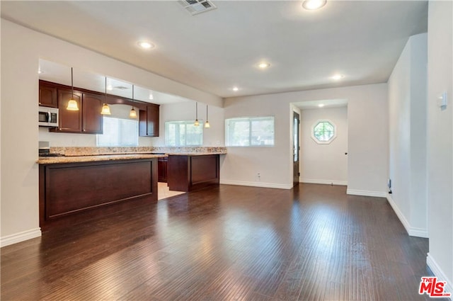 kitchen featuring decorative light fixtures, dark hardwood / wood-style flooring, kitchen peninsula, and dark brown cabinetry