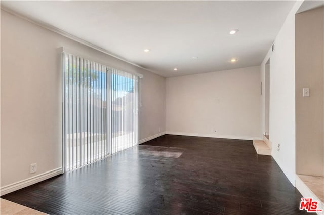 unfurnished room with dark hardwood / wood-style flooring