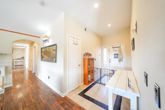 hallway featuring vaulted ceiling and light wood-type flooring