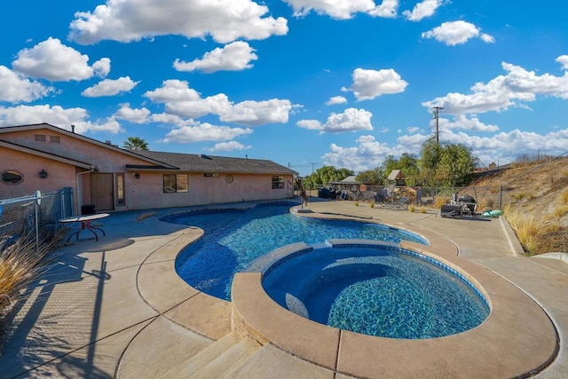 view of pool featuring a patio area and an in ground hot tub