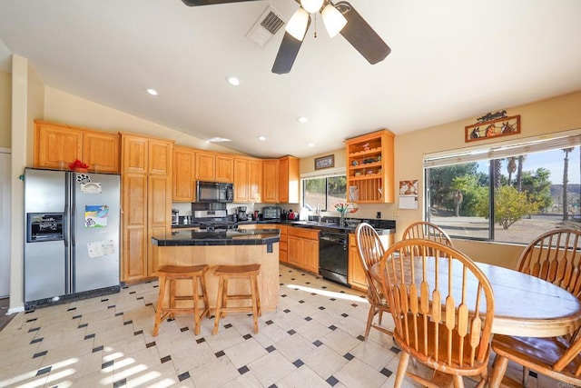 kitchen featuring vaulted ceiling, a wealth of natural light, a center island, and black appliances