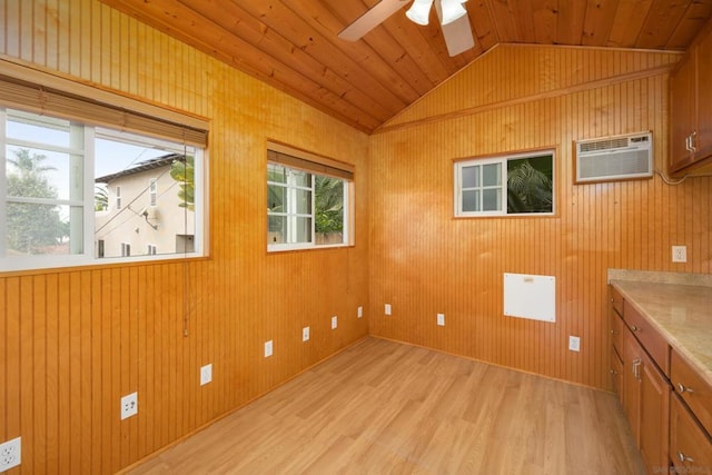 empty room with vaulted ceiling, light hardwood / wood-style floors, wooden ceiling, ceiling fan, and a wall mounted AC