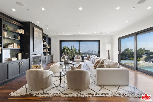 living room with built in features and dark hardwood / wood-style floors