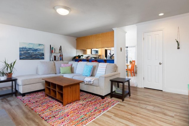 living room with light hardwood / wood-style flooring and crown molding