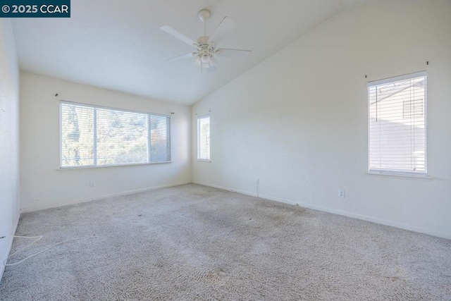 carpeted spare room featuring ceiling fan and vaulted ceiling