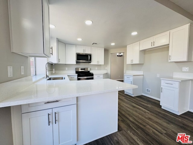 kitchen featuring sink, white cabinets, appliances with stainless steel finishes, and kitchen peninsula