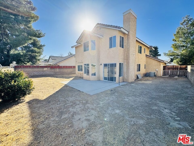 back of property with central air condition unit and a patio