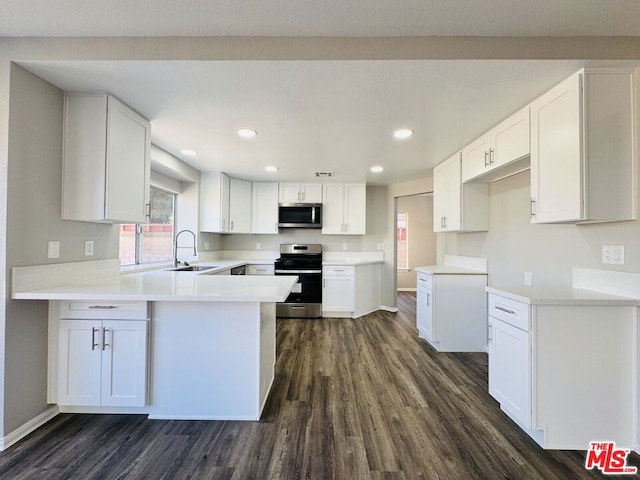 kitchen with white cabinets, kitchen peninsula, and appliances with stainless steel finishes