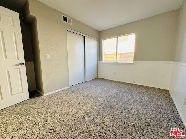 unfurnished bedroom with a closet and carpet flooring