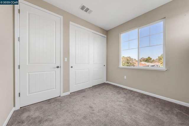 unfurnished bedroom featuring a closet and light carpet