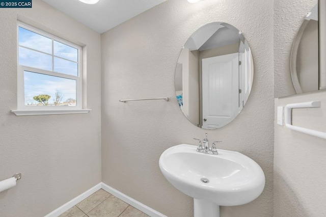 bathroom featuring a healthy amount of sunlight, tile patterned floors, and sink