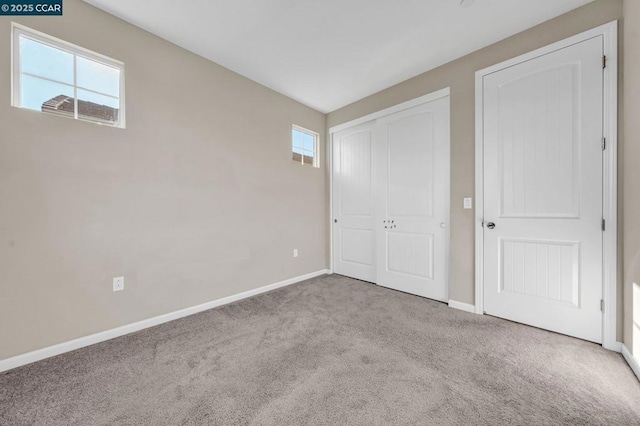 unfurnished bedroom with light colored carpet and multiple windows