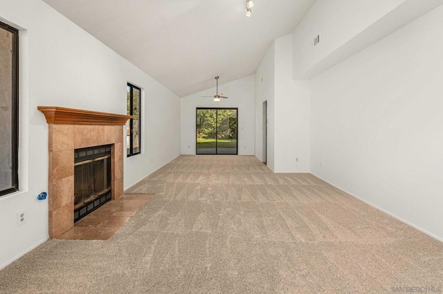 unfurnished living room featuring light carpet, vaulted ceiling, a fireplace, and ceiling fan