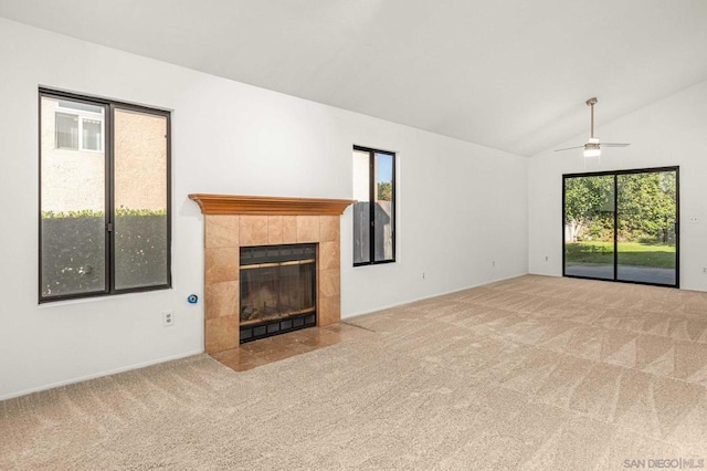 unfurnished living room featuring light carpet, ceiling fan, a fireplace, and lofted ceiling