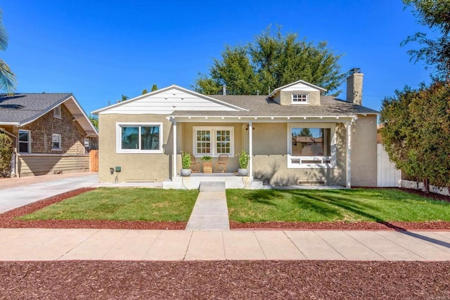 view of front of home featuring a chimney, a front yard, fence, and stucco siding