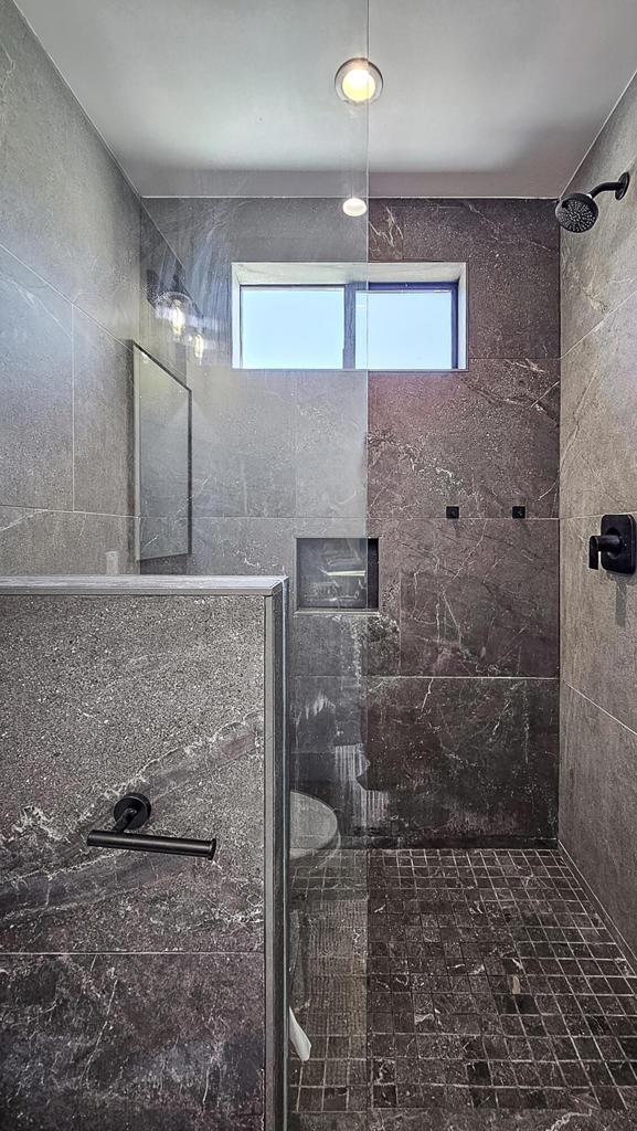 bathroom featuring a wealth of natural light and a tile shower