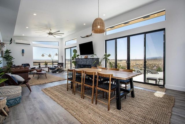 dining area with a wealth of natural light, a wall mounted AC, and wood-type flooring