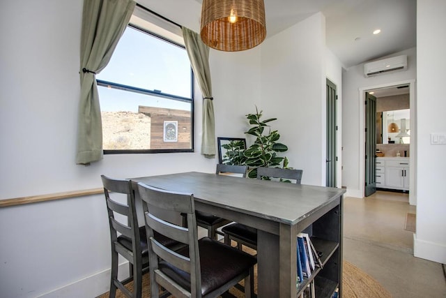 dining area featuring a wealth of natural light, an AC wall unit, and concrete floors