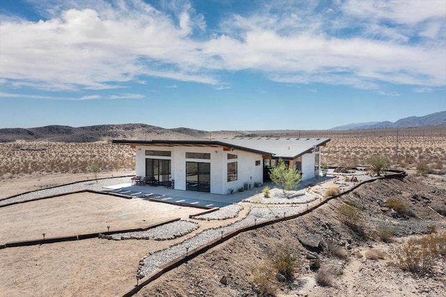 rear view of property featuring a patio area and a mountain view