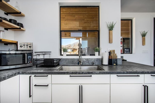 kitchen featuring sink and white cabinets