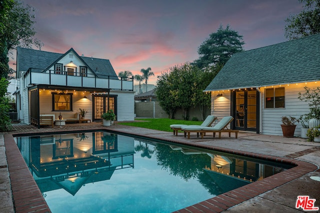 pool at dusk with a patio