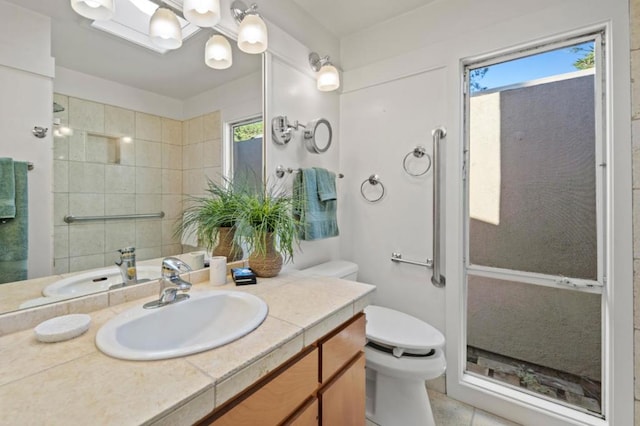 bathroom with a healthy amount of sunlight, toilet, a shower with door, and vanity