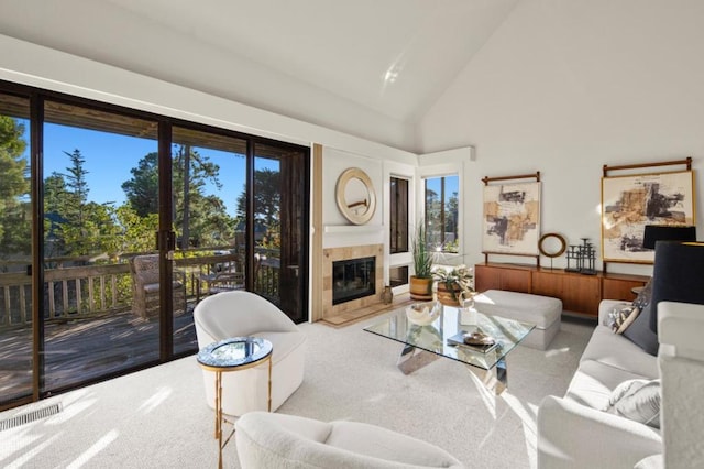 living room featuring high vaulted ceiling, light colored carpet, and a fireplace