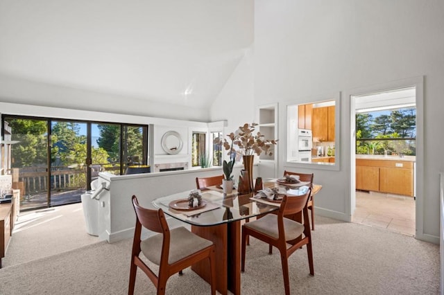 carpeted dining space with a high ceiling