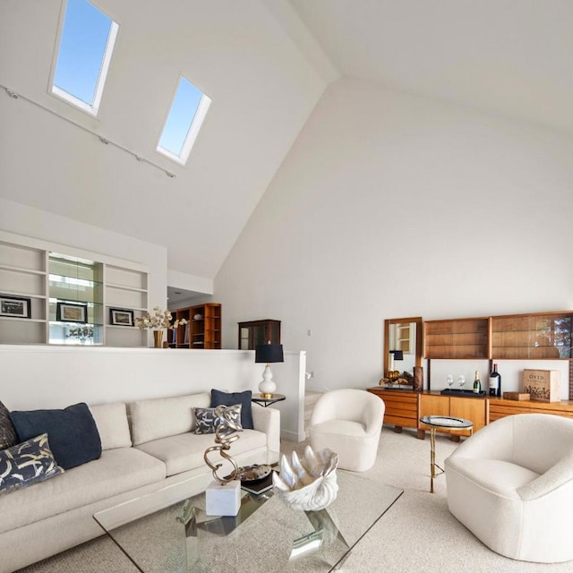 carpeted living room featuring a skylight and high vaulted ceiling