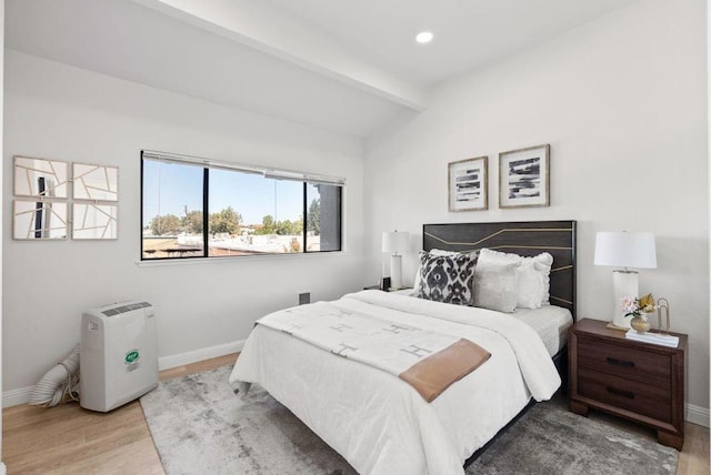 bedroom featuring lofted ceiling with beams and light wood-type flooring