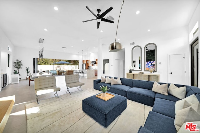 living room featuring ceiling fan, a high ceiling, and a wealth of natural light